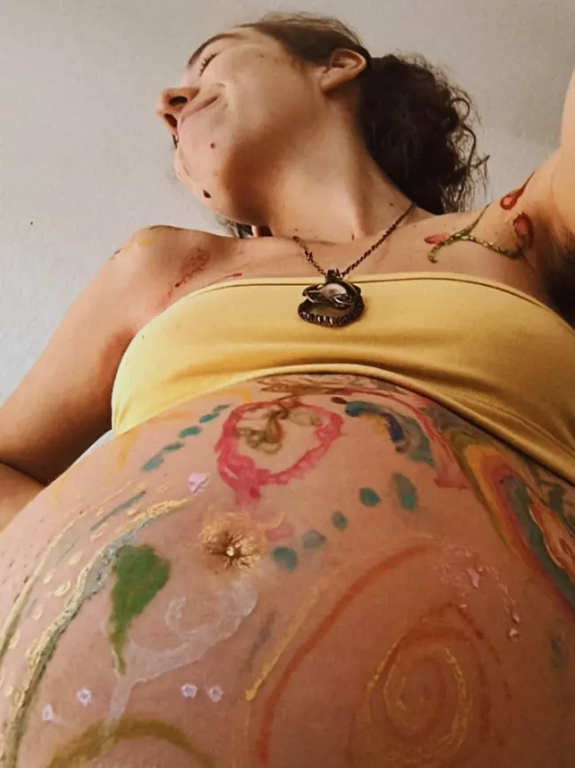 Gestante com a barriga pintada em um chá de bênçãos